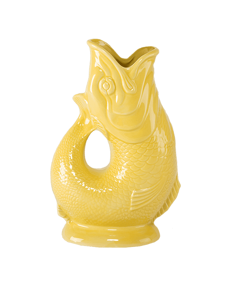 Die Gluckigluck Karaffe X-Large Gelb von Gluckigluck ist eine glänzend gelbe Keramikkanne in Form eines Fisches mit detaillierten Schuppen, offenem Maul und gebogenem Schwanz, die aufrecht auf einem kleinen runden Sockel steht.