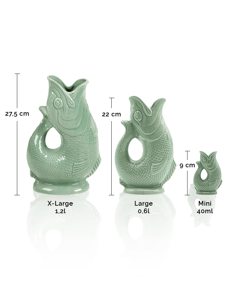 Drei Gluckigluck-Karaffen in Salbeigrün (X-Large: 27,5 cm/1,2 l, Large: 22 cm/0,6 l, Mini: 9 cm/40 ml) von Gluckigluck stehen aufrecht auf einer reflektierenden Oberfläche; jede macht beim Eingießen das ikonische „Gluck“-Geräusch und dient gleichzeitig als Vase oder Krug.