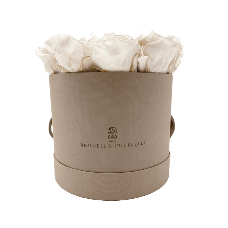Eine runde beige Hutschachtel mit Griffen enthält cremefarbene Rosen. Auf der Vorderseite sind das Logo und der Markenname von Brunello Cucinelli aufgedruckt.
