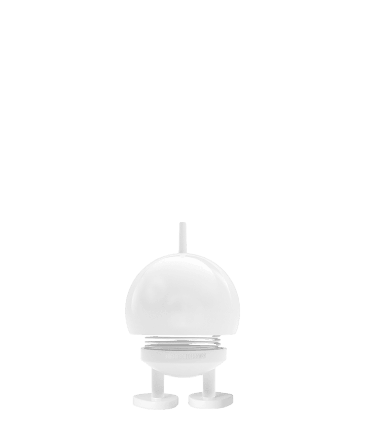 Der Hoptimist Bumble Small White von Hoptimist verfügt über ein kleines, kuppelförmiges Design mit runden Füßen und einer kurzen Antenne, ähnelt einem minimalistischen Spielzeugroboter und strahlt vor einem schlichten Hintergrund Optimismus aus.