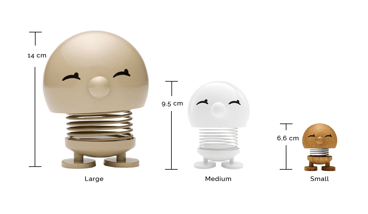 Drei lächelnde, runde Figuren mit Federsockel in den Größen groß (14 cm, beige), mittel (9,5 cm, weiß) und klein (6,6 cm, braun), von links nach rechts mit Höhenangaben angezeigt.