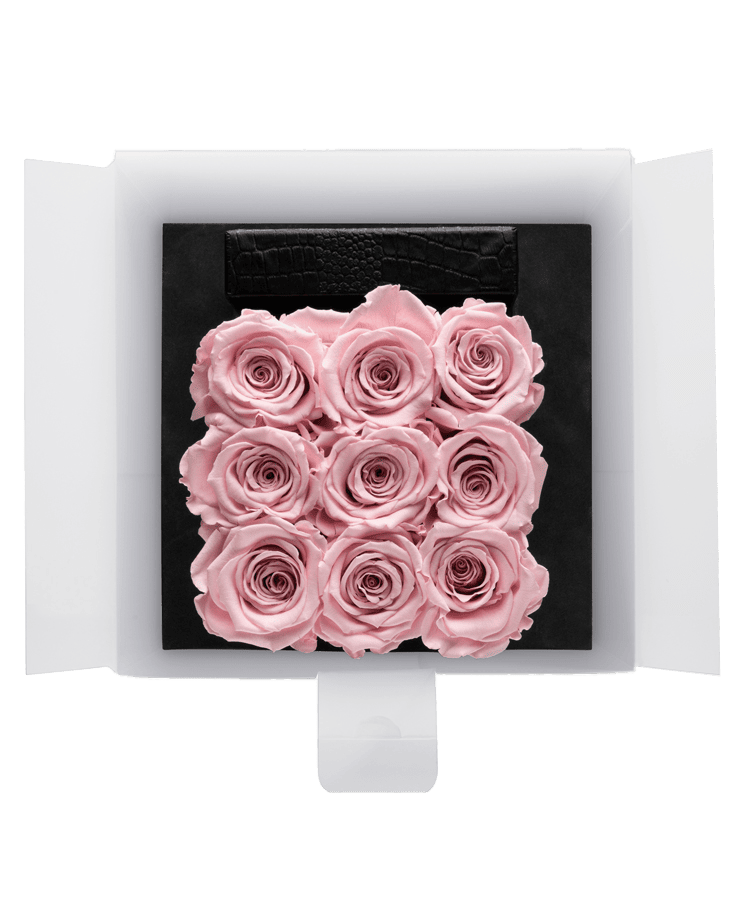 Die Ivoryi Flowerbox Medium Black Blush Rose von Ivoryi & Friends enthält neun konservierte Rosen in einem 3x3-Raster, elegant präsentiert in einer schwarzen Box mit offener weißer Verpackung. Handgefertigt in Deutschland, verleiht sie jedem Raum dauerhafte Schönheit.
