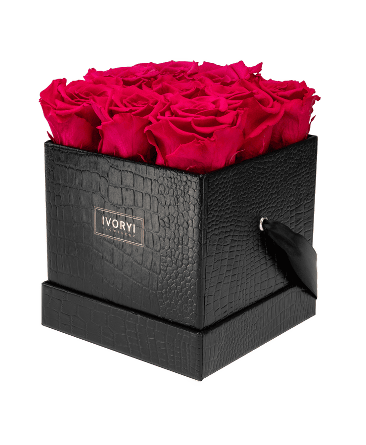 Die Ivoryi & Friends Flowerbox Medium Black New Pink besticht durch eine strukturierte schwarze Box mit leuchtend rosa Rosen, einem kleinen Henkelband und einem „IVORY!“-Etikett auf der Vorderseite. Handgefertigt in Deutschland für einen Hauch von Eleganz.