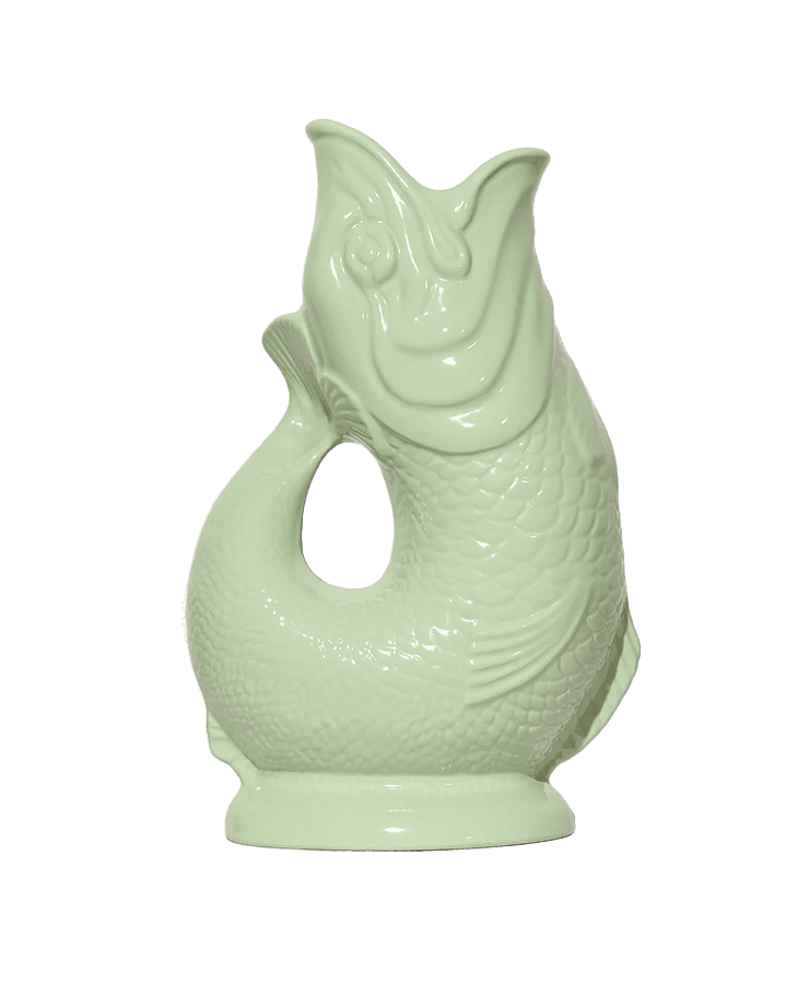 Der Gluckigluck Karaffe X-Large Pistazie Grün von Gluckigluck ist ein fischförmiger Keramikkrug mit strukturierten Schuppen, einem offenen Ausguss und einem gebogenen Henkel in hellem Pistaziengrün.