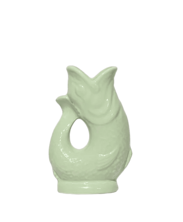 Der Gluckigluck Karaffe Mini Pistazie Grün von Gluckigluck ist ein hellgrüner, fischförmiger Keramikkrug mit offener Mündung und geschwungenem Henkel, der in England hergestellt wird und sich perfekt als einzigartiges Mittelstück eignet.